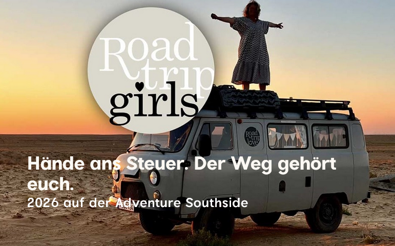 Susanne steht auf dem Dach ihres Camper Vans und genießt die Freiheit